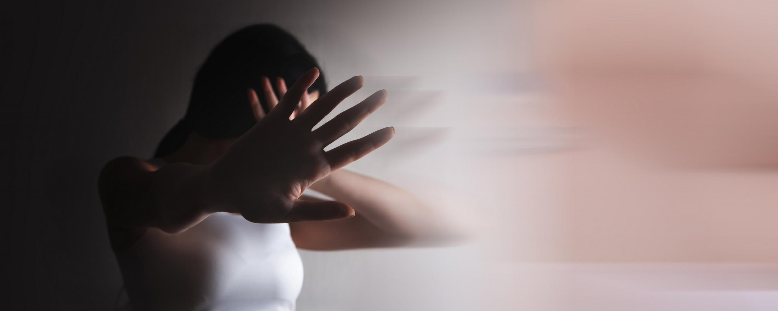 Vrouw steekt hand uit om zichzelf te beschermen